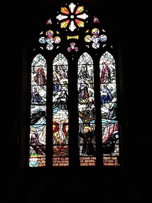 Stained glass window of the Church of San Francesco in Viterbo, depicting religious scenes with intricate details.