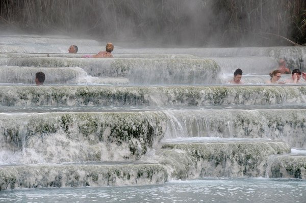 Terme Bullicame a Viterbo con piscine terrazzate e persone che si rilassano nell'acqua termale.
