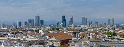 Vista panoramica di Milano con il moderno skyline e il Duomo sullo sfondo in una giornata limpida.