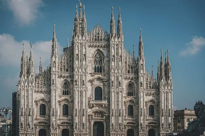 Front view of Milan Cathedral with a blue sky in the background.