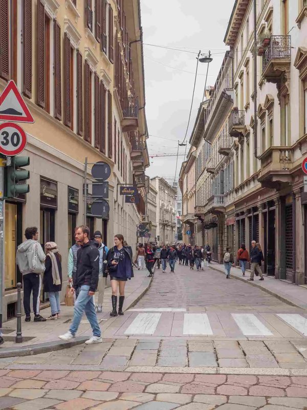 Via Brera in Milan with historic buildings, pedestrians, and an urban atmosphere.