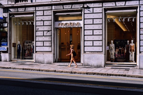 Storefront of an Italian mid-market fashion shop on a pedestrian street, with a mannequin in the window.