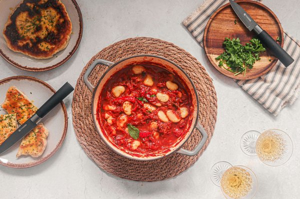 Tomato-based stew with white beans simmering in a pot, Milanese tripe style.