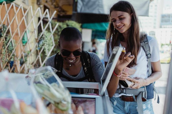 Two people exploring a local market with fresh produce in Milan.