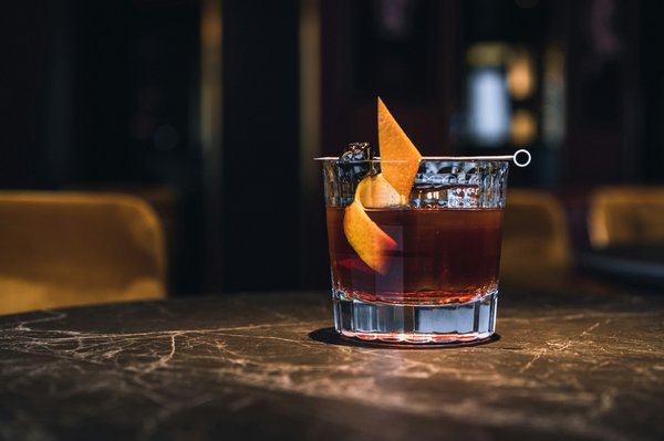 Negroni-style cocktail in a rocks glass garnished with an orange twist.