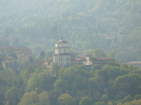 Vista panoramica di Monte dei Cappuccini a Torino, circondato da alberi e colline verdi.