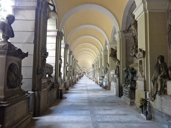 Corridoio con archi e sculture nel Cimitero Monumentale di Torino, Italia.