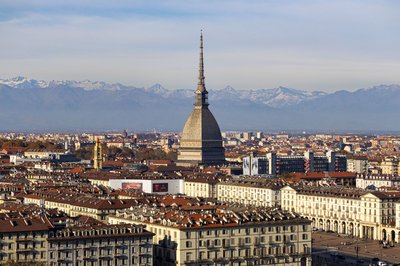 Vista panoramica di Torino con la Mole Antonelliana e le Alpi sullo sfondo in una giornata limpida.