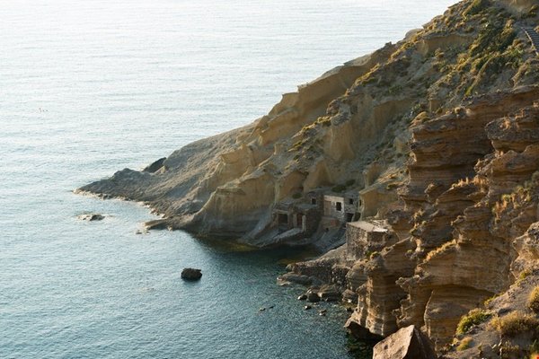 Pollara Beach in Salina with rocky cliffs and coastal structures, part of the Aeolian Islands.