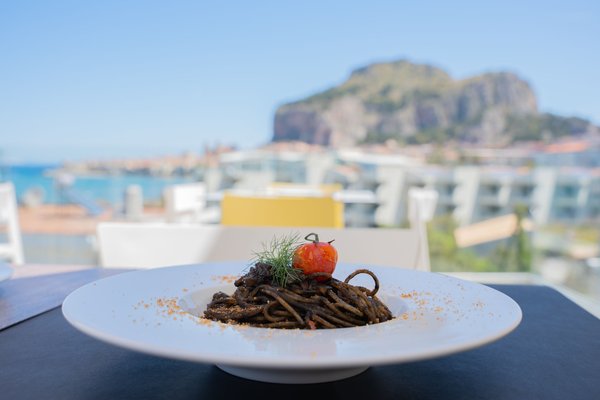 Seafood pasta dish with coastal background, perfect for Aeolian Islands guide and fresh seafood dinner.