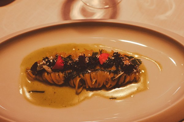 Fine-dining pasta dish with truffle, caviar, gold leaf, and edible flower garnish.