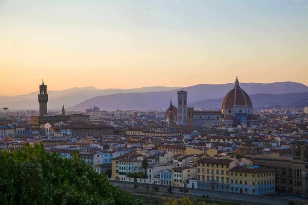 Panoramic view of Florence at sunset from Piazzale Michelangelo with the Duomo and Palazzo Vecchio in focus.