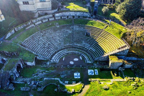 Aerial view of the Roman Theatre of Fiesole, its stone tiers carved into the hillside.