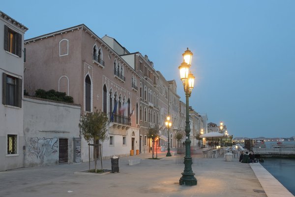 La passeggiata delle Zattere a Venezia al crepuscolo, con i lampioni accesi lungo il Canale della Giudecca.