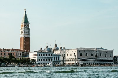 Veduta del Campanile di San Marco e di Palazzo Ducale a Venezia con il mare in primo piano.