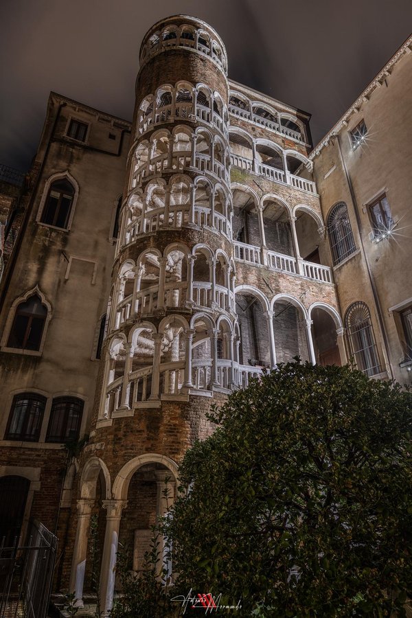 The exterior spiral staircase of the Scala Contarini del Bovolo in Venice, rising through tiers of arched loggias.
