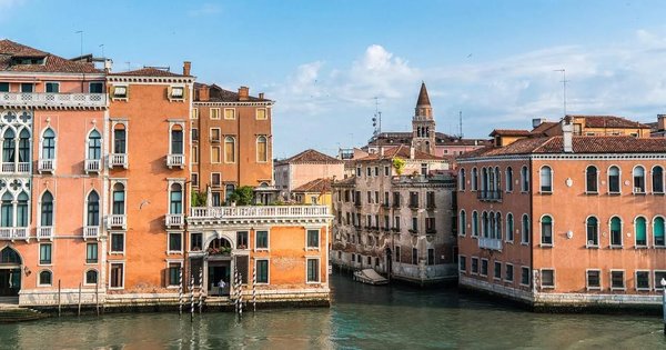 Venetian canals with historic buildings and Venetian architecture under a clear sky.