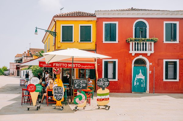 Colorful Venetian bacaro storefront with a handwritten sign advertising cicchetti for €3.
