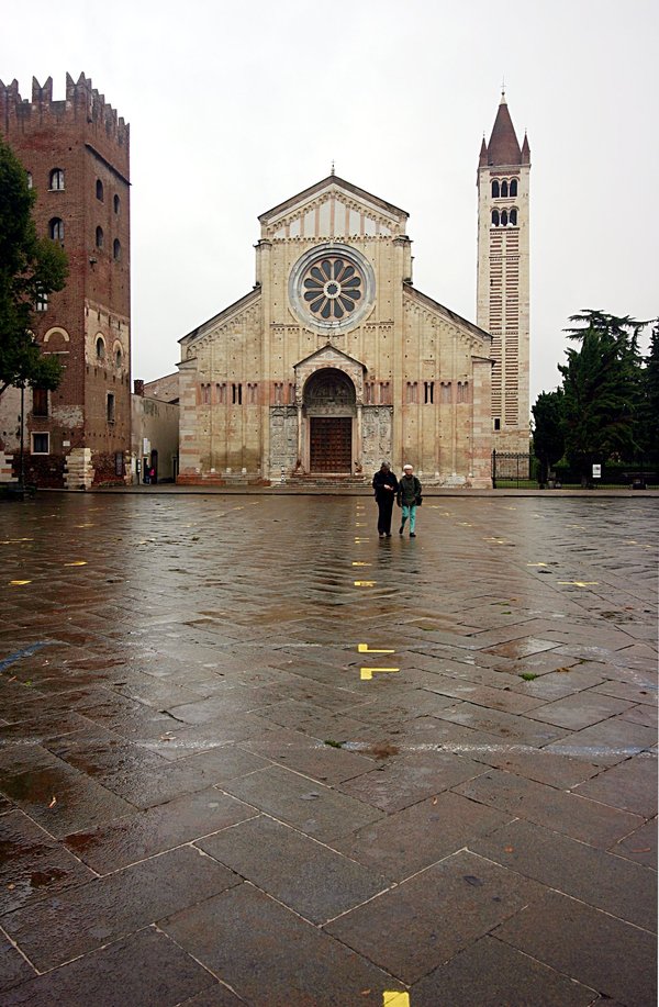 The Romanesque facade of the Basilica of San Zeno Maggiore in Verona, with its rose window and bell tower.
