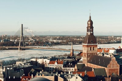 Panoramic view of Riga with Riga Cathedral and Vanšu Bridge over the Daugava River on a clear day.