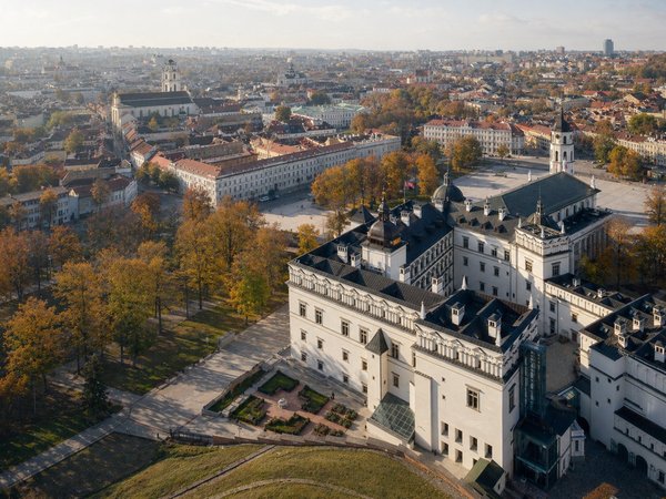 Vista aerea del Palazzo dei Granduchi di Lituania a Vilnius con colori autunnali e paesaggio urbano sullo sfondo.