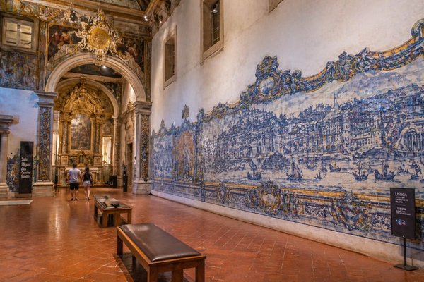 Interior of the National Tile Museum in Lisbon with walls adorned with painted tiles and historic architectural details.