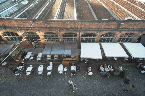 Aerial view of outdoor tables and a brick industrial building at LX Factory in Lisbon.