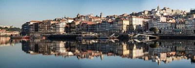 Panoramic view of Porto with the Ribeira district and the Douro River reflecting the colorful buildings.