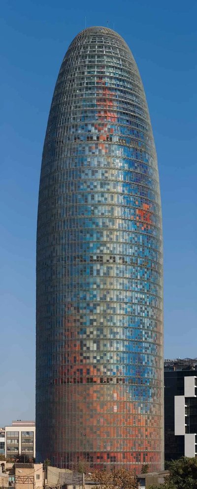 View of the Torre Glòries in Barcelona with a clear blue sky in the background.