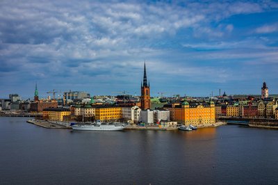 Panoramic view of Stockholm featuring Riddarholmen Church and historic waterfront buildings.