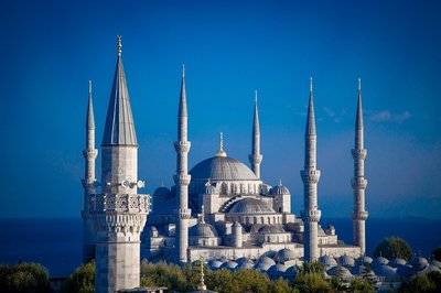 The Blue Mosque in Istanbul with its minarets and domes under a deep blue sky.