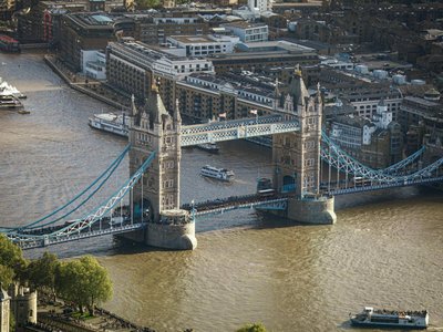 Aerial view of Tower Bridge in London with the River Thames and cityscape in the background.