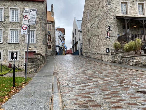 Cobblestone street with historic stone buildings in the heart of Old Quebec City, Canada.