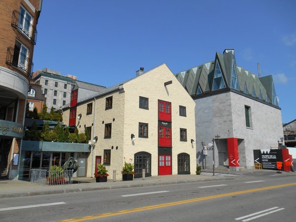 Facade of the Musée de la Civilisation in Quebec City with historic buildings and a blue sky.