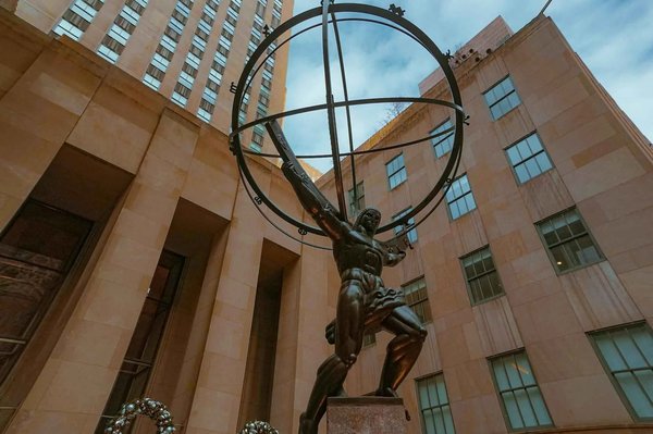 Statua di Atlante al Rockefeller Center a New York, con edifici circostanti e cielo sereno.
