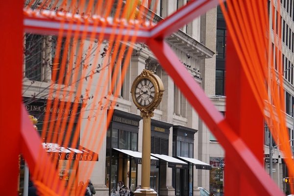 Orologio decorativo nel Flatiron District di New York con decorazioni natalizie e dettagli architettonici.