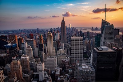 Panoramic view of New York City skyline at sunset with the Empire State Building in the center.