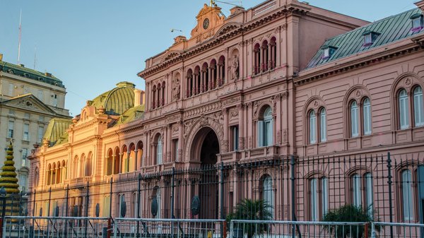 Facciata della Casa Rosada a Buenos Aires al tramonto, con dettagli architettonici e colori vivaci.