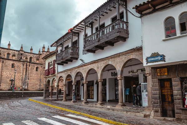 Strada acciottolata con archi e balconi coloniali nel quartiere San Blas di Cusco, Perù.