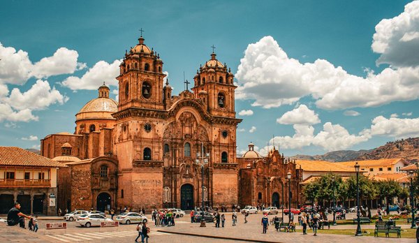 Cattedrale di Cusco con cielo blu e persone nella piazza, punto di riferimento iconico del Perù.