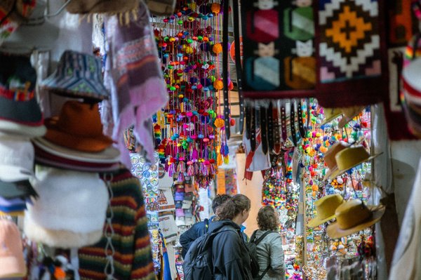 Mercato Wanchaq a Cusco con tessuti tradizionali, cappelli e decorazioni colorate.