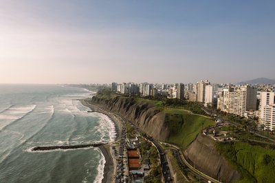 Panoramic view of Miraflores cliffs and Lima coastline with modern buildings and clear sky.