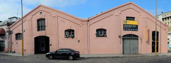 Pink facade of Museo del Carnaval in Montevideo with visible sign and distinctive architectural details.
