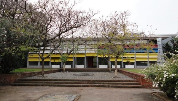 Edificio moderno con facciata colorata e alberi spogli nel Parque Rodó, Montevideo.