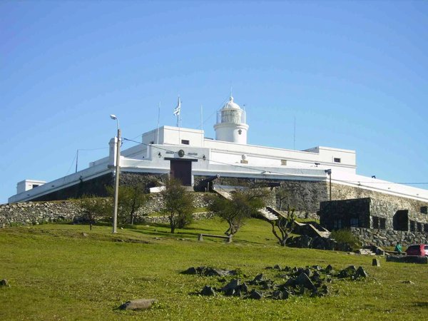 View of Fortaleza del Cerro in Montevideo with blue sky and green lawn in the foreground.