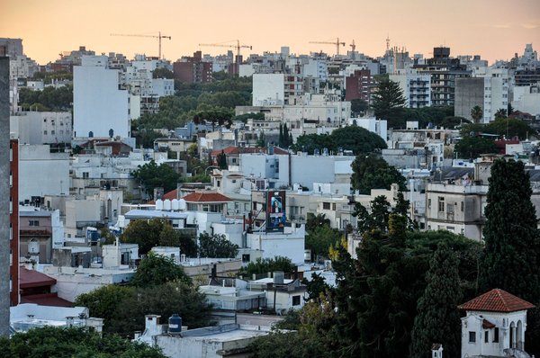 Vista panoramica del quartiere residenziale di Carrasco a Montevideo al tramonto, con edifici e alberi.